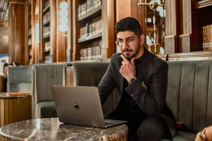 a man sitting on a couch using a laptop computer